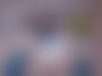 Hands use a laptop and a drawing tablet on a wooden table with coffee and a small plant, conveying a productive workspace.