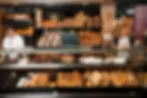 Display of freshly baked breads, pastries, and pretzels inside a traditional neighborhood bakery in Lisbon, Portugal