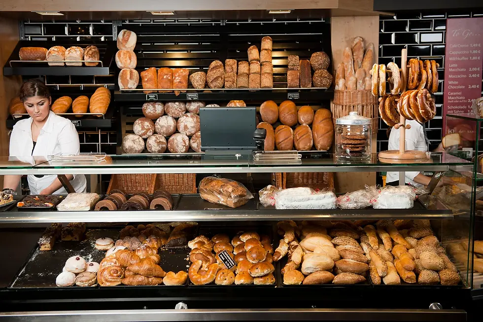 Display of freshly baked breads, pastries, and pretzels inside a traditional neighborhood bakery in Lisbon, Portugal