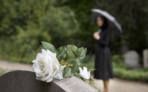 Woman standing solemnly at a gravesite, representing the importance of final expense life insurance to cover end-of-life cost