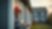 Eye-level view of a home inspector examining the exterior of a house