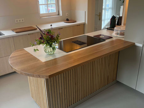 Moderne Kücheninsel aus Holz mit geschwungener Front und Spüle