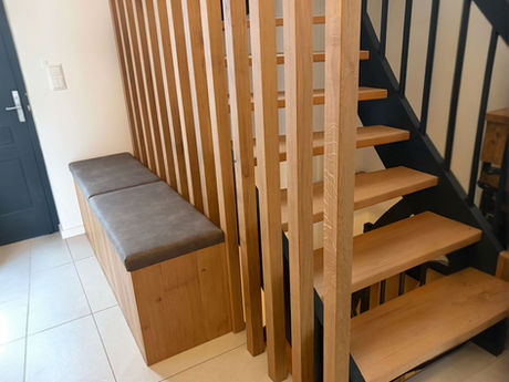 Holztreppe mit vertikalen Stäben als Geländer und integrierter Garderobe