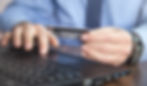 a man entering his credit card information online to check his balance on his line of credit