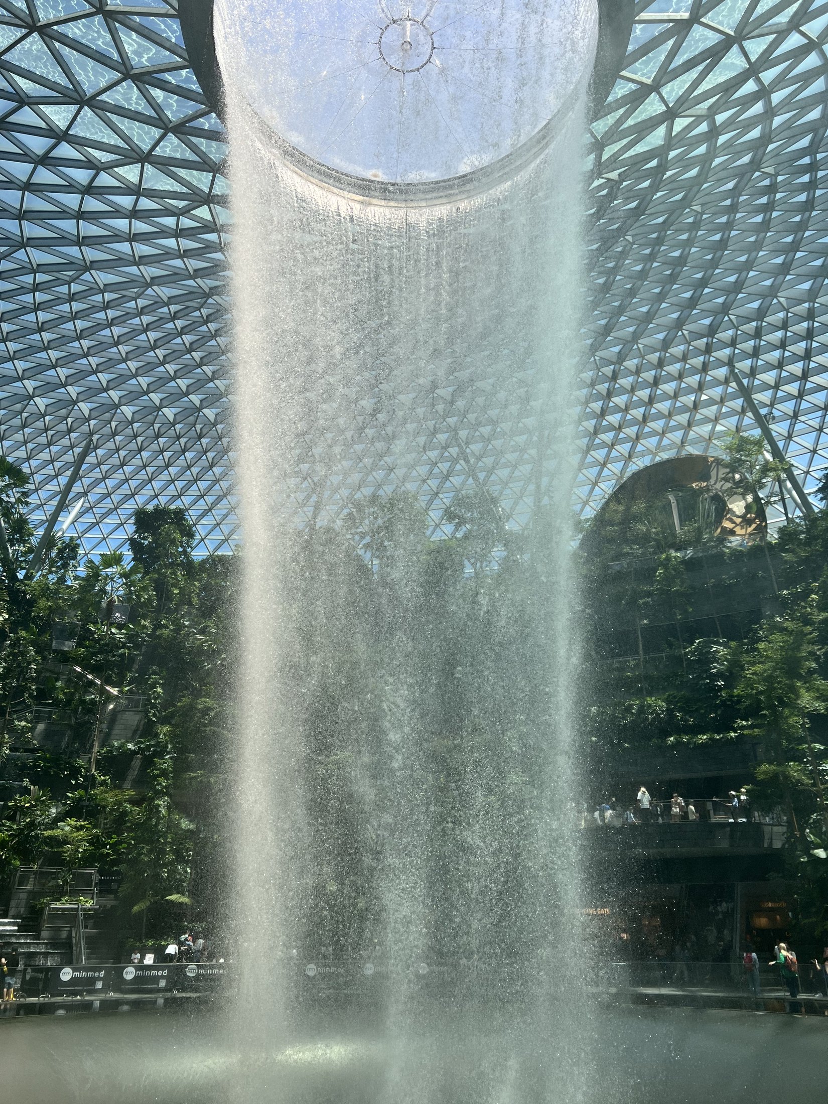 Waterfall beneath a monumental glass dome, framed by greenery — original ÉDITON archive