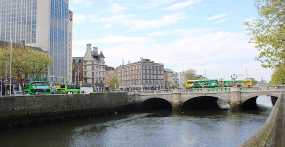 Photographie de l'O'Connell Bridge à Dublin avec bus urbains, architecture du centre-ville et rivière Liffey, scène de rue irlandaise authentique, Lawscape.
