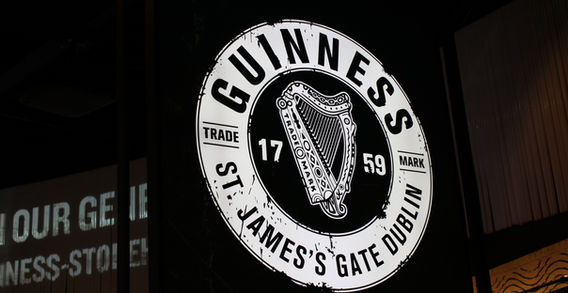Logo circulaire blanc de la marque Guinness Trade Mark avec la harpe et l'inscription St. James's Gate Dublin 1759.