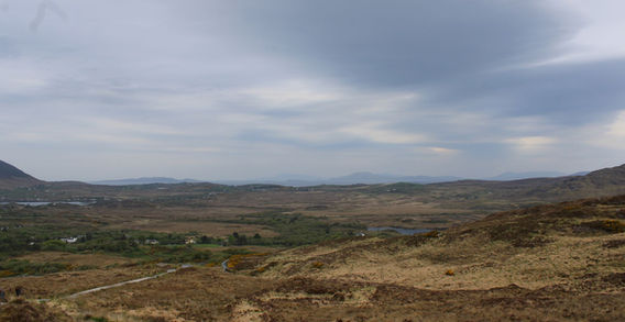 Vaste plaine sauvage de tourbières s'étendant jusqu'aux chaînes de montagnes lointaines, vue depuis les hauteurs de Diamond Hill dans le Connemara.