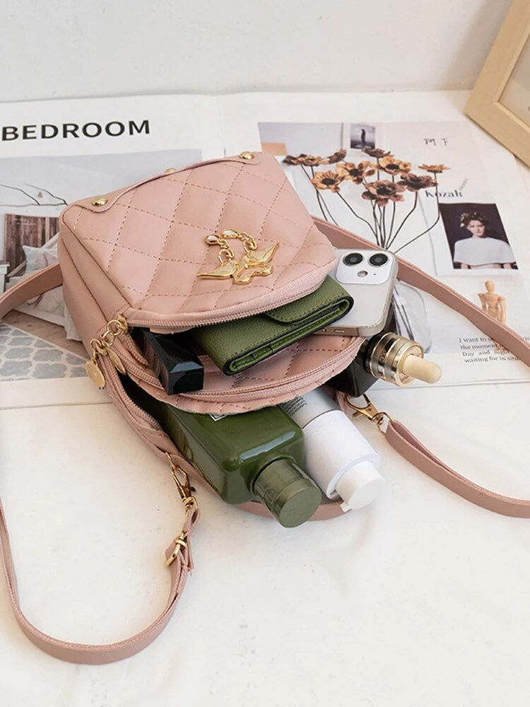 Thumbnail: Pink quilted crossbody bag with contents visible