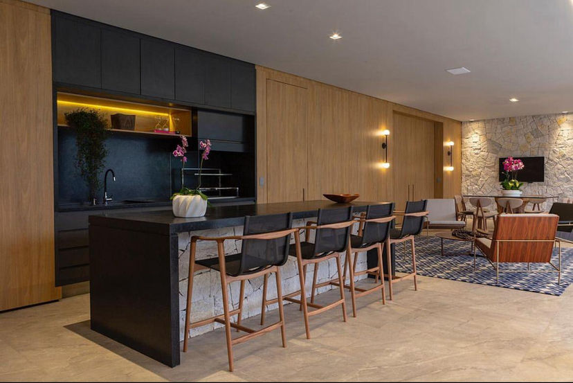 interior de cozinha com acabamento em madeira e mármore, e iluminação planejada