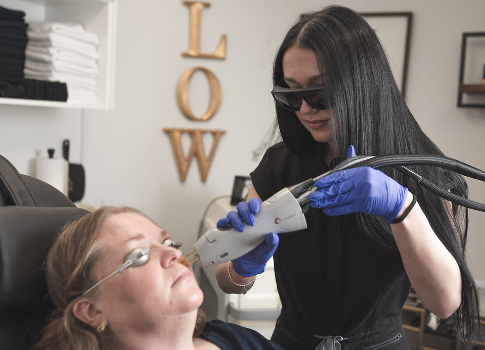 Client with eye protection receiving laser hair removal treatment on her face