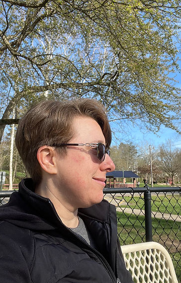 Dr. Jessica sitting on a bench in a park