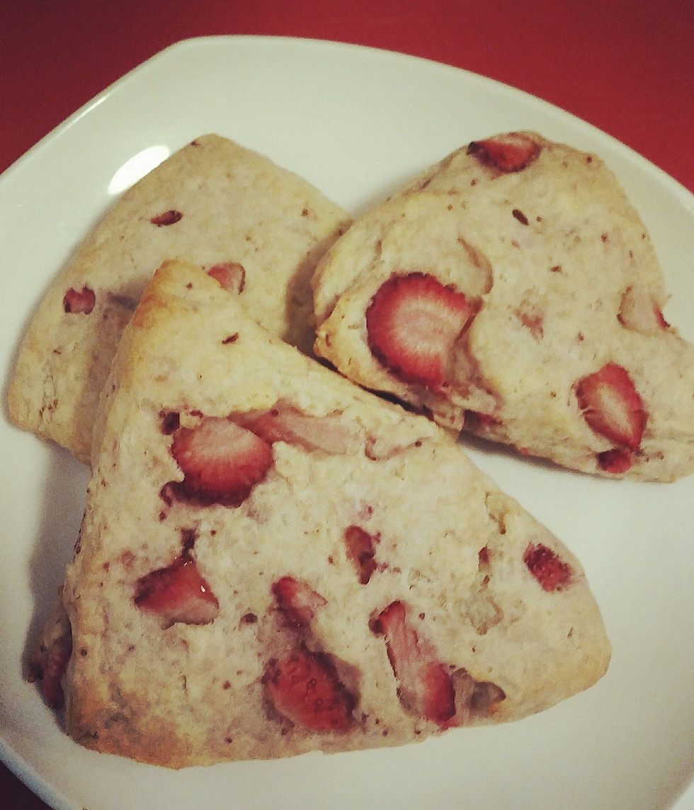Image of three strawberry scones on a white plate on a red background