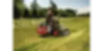 Thumbnail: A man operating a Bobcat mower cutting grass in a field.