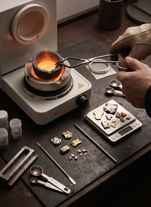 Jewelry artisan preparing a proprietary metal alloy in a graphite crucible at an in-house workshop