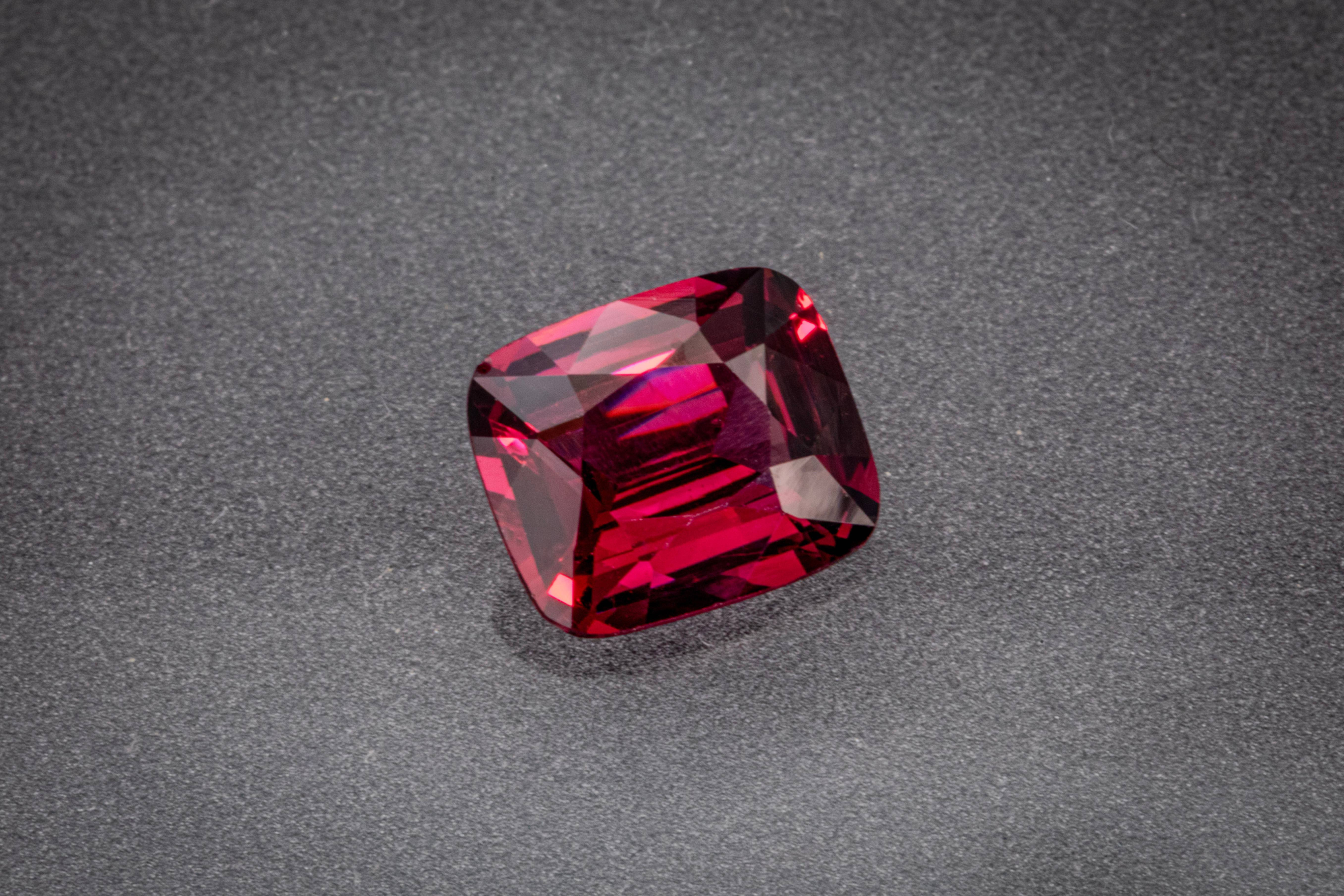 Natural 2.51 ct Umbalite garnet from Tanzania, showing a crimson-raspberry cushion cut.