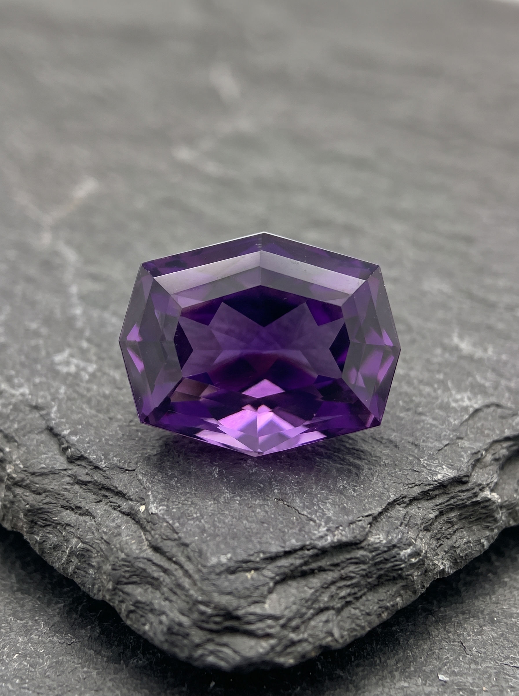Natural 5.845 ct amethyst from Artigas, Uruguay, with royal-violet color and an architectural fantasy cut.