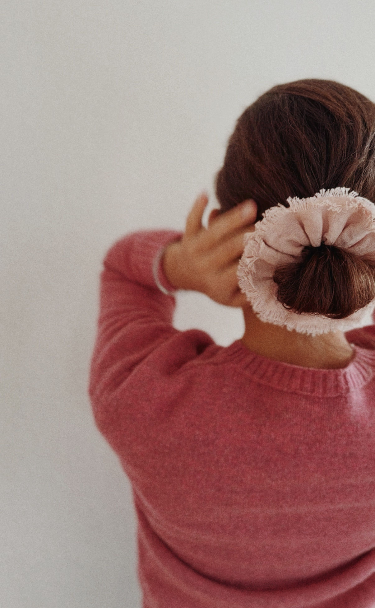 Frau trägt den naturgefärbten Baumwoll-Scrunchie PERSEA im Haar. Ein Beispiel für Slow Fashion und pflanzliche Farbtöne.