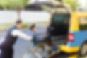 driver helping man on wheelchair getting into taxi.jpg