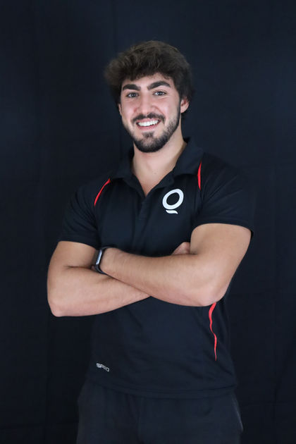 Home entrenador QSPORT amb camisa negra amb les mans creuades