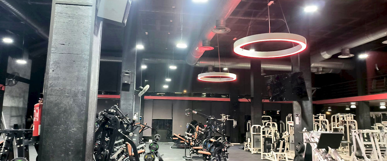 Interior de gimnàs amb màquines de fitness i llums circulars a la part superior QSPORT Principal