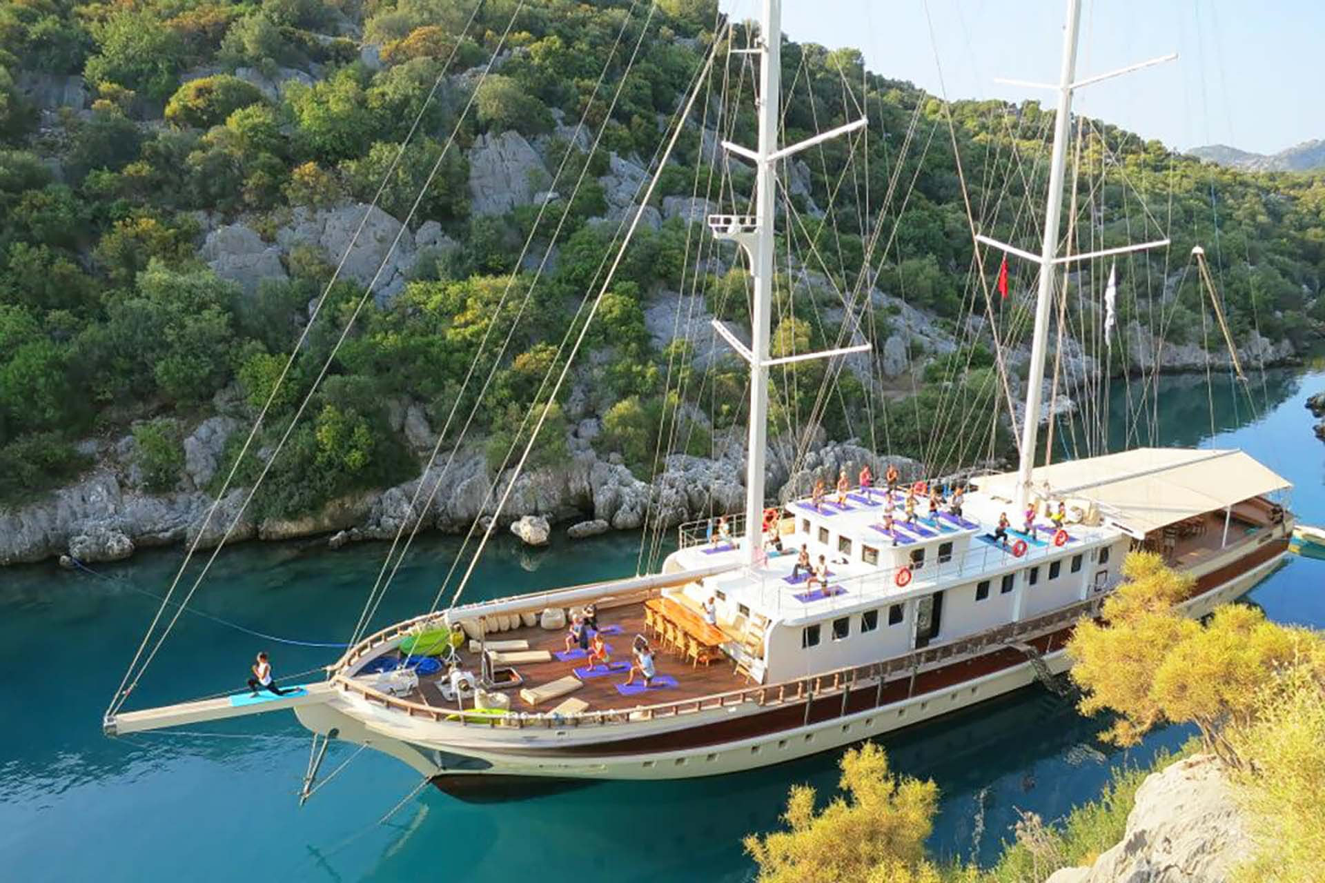 Guests practicing yoga in a beautiful bay onboard TERSANE 8 gulet in Turkey 
