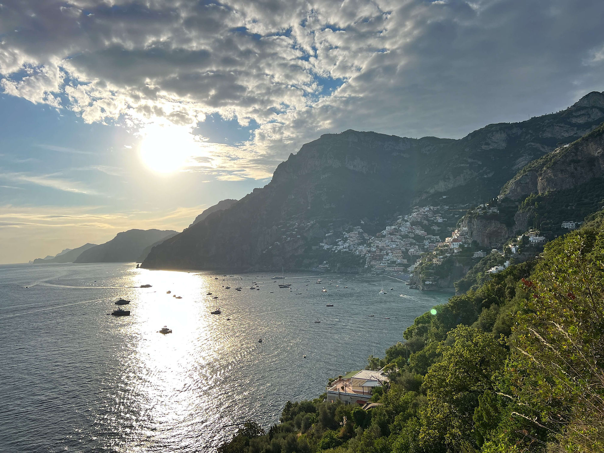Positano town on a sunny July day with yachts on anchor