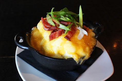 Loaded Mashed Potatoes. Roasted garlic mashed potatoes with cheddar cheese bacon and green onion.