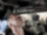 man looking for spy device under car