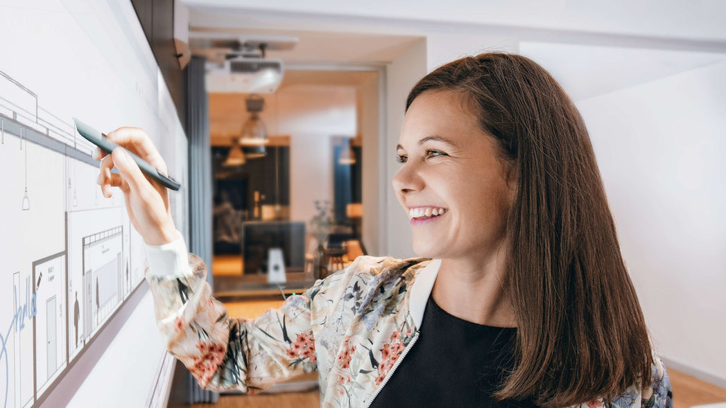 Kreative Strategin bei der Konzeption an einer digitalen Idea Wall in einem modernen Architekturbüro.Visualisierung von Innovationsprozessen und digitaler Transformation im technischen Mittelstand durch BRAUN FRIEDRICH.