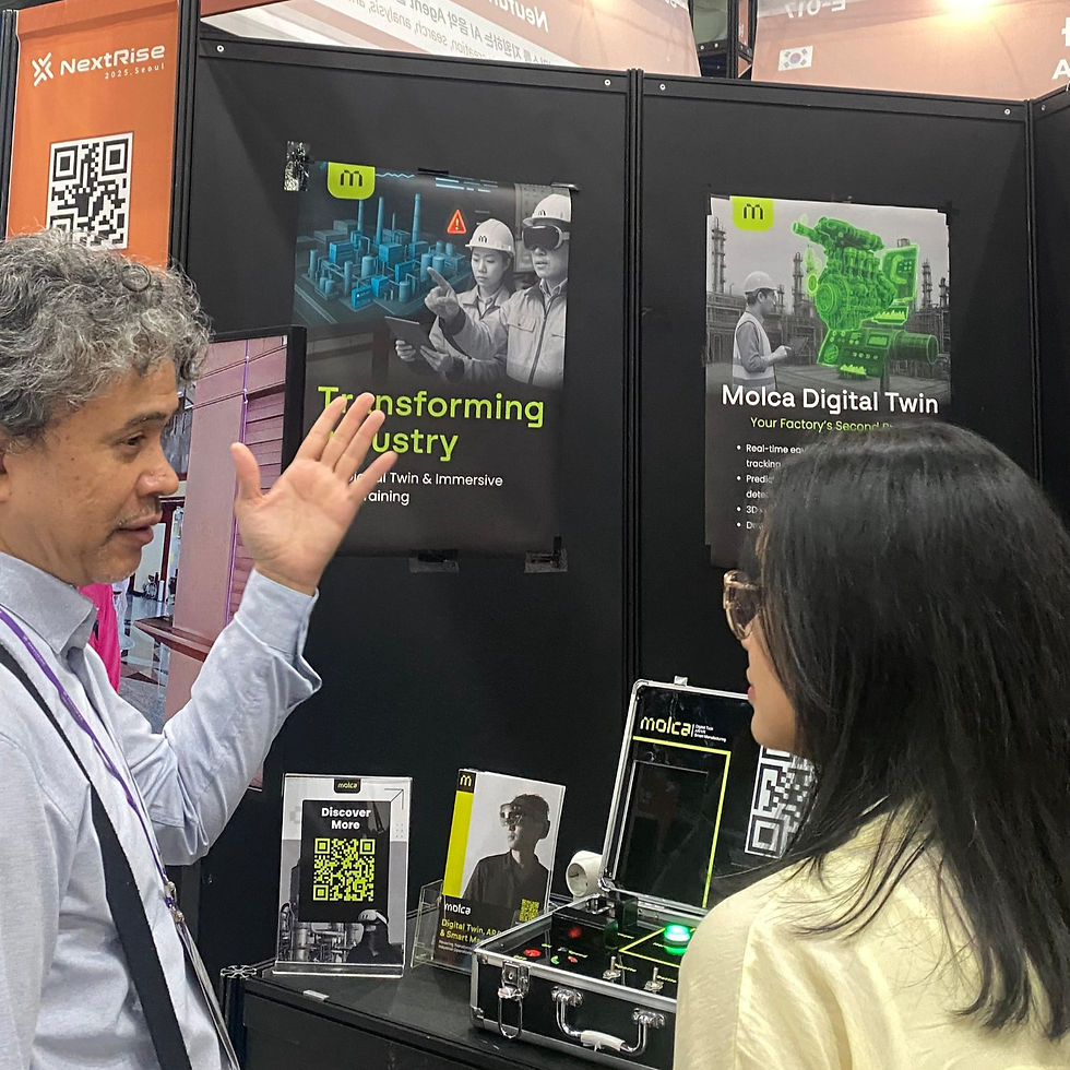 Man gestures to a woman at a tech booth. Posters show industrial themes with "Transforming Industry" text. QR codes and devices visible.