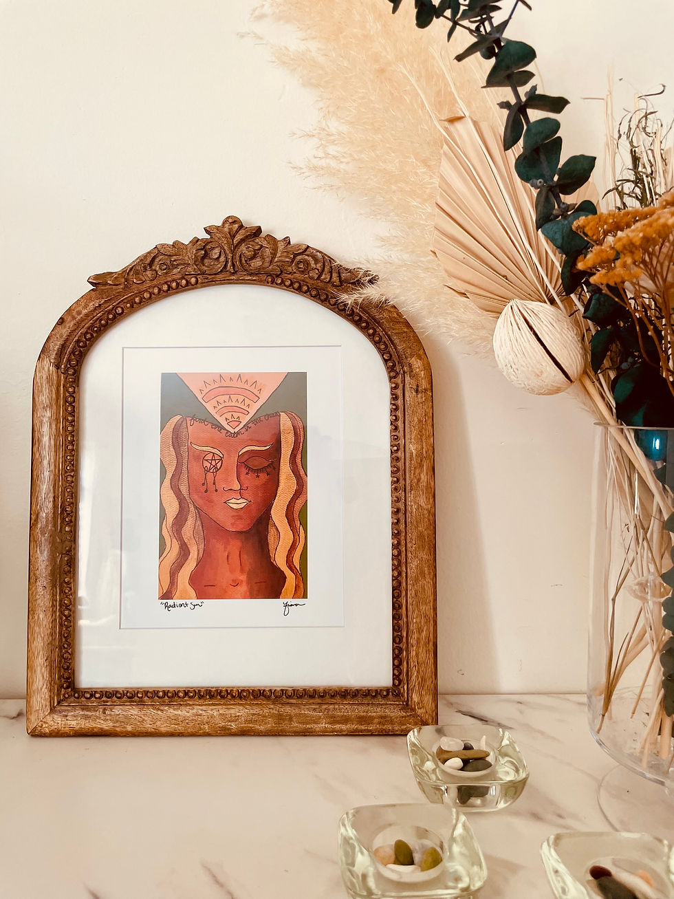 Art Print of the Radiant Sun goddess in a bohemian style round frame. She has gold and bronze hair, a pentacle eye, and sunlight leaving the forehead. A perfect art print for a meditation room. 