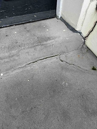 Cracked mastic asphalt surface near door entrance.