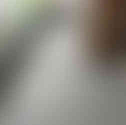 Freshly coated grey flat roof with neat edges and adjacent brick wall.