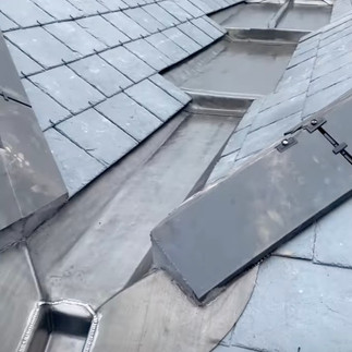 Lead chutes and box gutters for efficient water drainage on a building's roof.