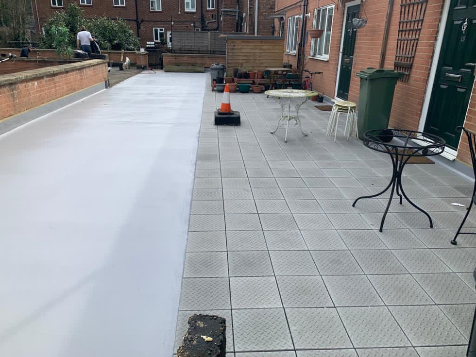 The image shows a repaired roof clean and well-arranged . The patio floor is covered with square tiles. There's a dining table surrounded by chairs placed on the patio.