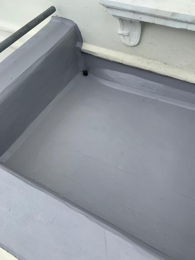The image presents a waterproof balcony grey rectangular structure on a white background. The structure features a metal bar along one edge and is accompanied by pipes on both the left and right sides.