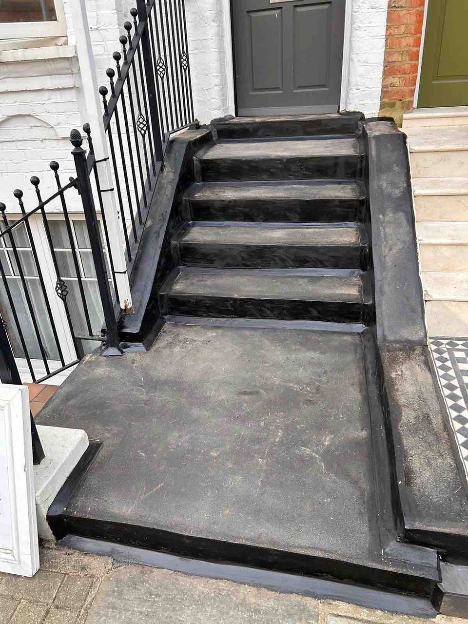 After asphalt waterproofing: Clean, newly protected stairs with smooth black coating, ensuring safety and protection from water damage.