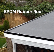 Flat EPDM rubber roof installed on a residential building, showing a clean, smooth black surface with greenery in the background.