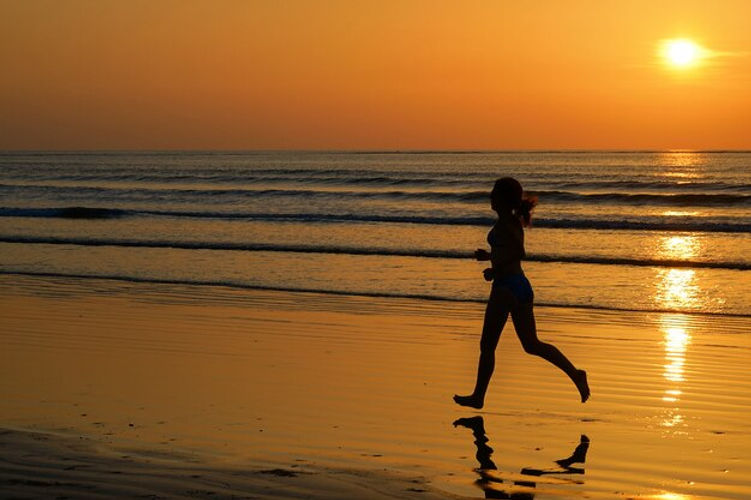 silhouette-woman-jogger-running-sunset-beach-with-reflection-fitness-sport-concept_146539-