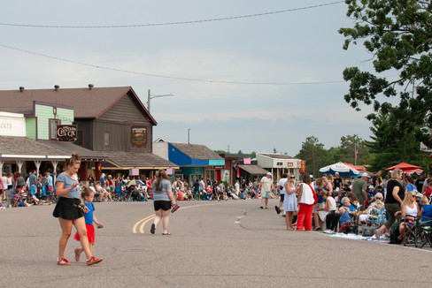 Scenes from the 2025 Nisswa Freedom Days Parade featuring floats, classic cars, local businesses, and community celebration.
