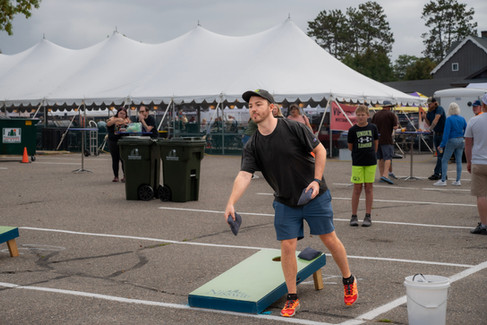 Crowds fill Downtown Nisswa under sunny skies during the 2025 Nisswa Fall Festival and Smokin’ Hot BBQ Challenge, with BBQ teams lined up, smoke rising from grills, and families enjoying the fall atmosphere.