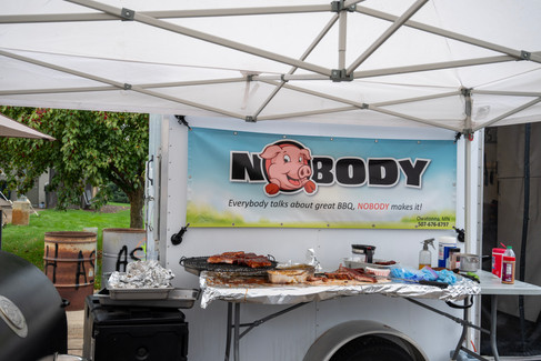 Crowds fill Downtown Nisswa under sunny skies during the 2025 Nisswa Fall Festival and Smokin’ Hot BBQ Challenge, with BBQ teams lined up, smoke rising from grills, and families enjoying the fall atmosphere.