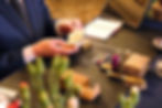 Antiques and vintage items on a valuation table with an expert appraising