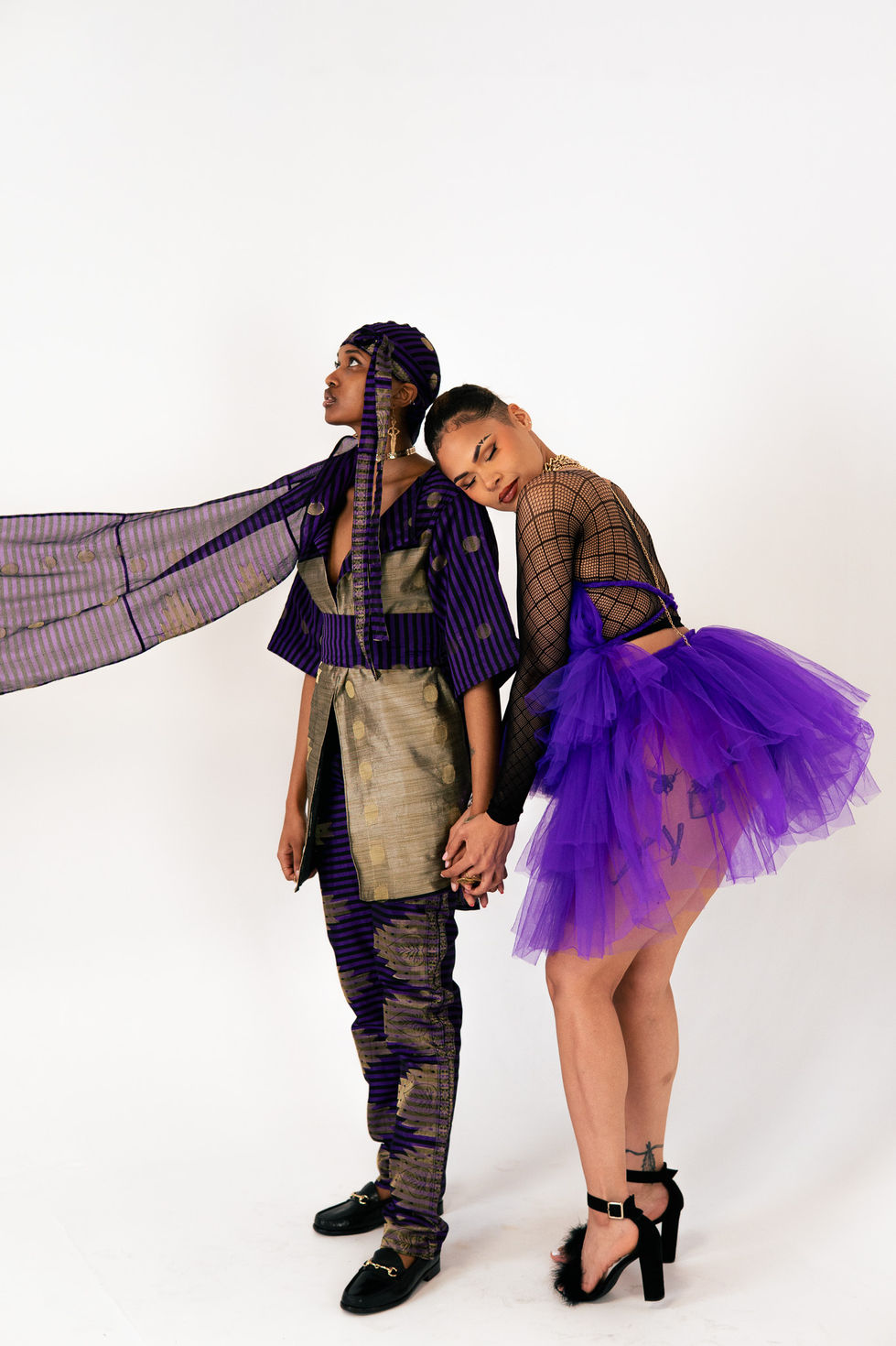 Two models in vibrant, avant-garde fashion outfits.
