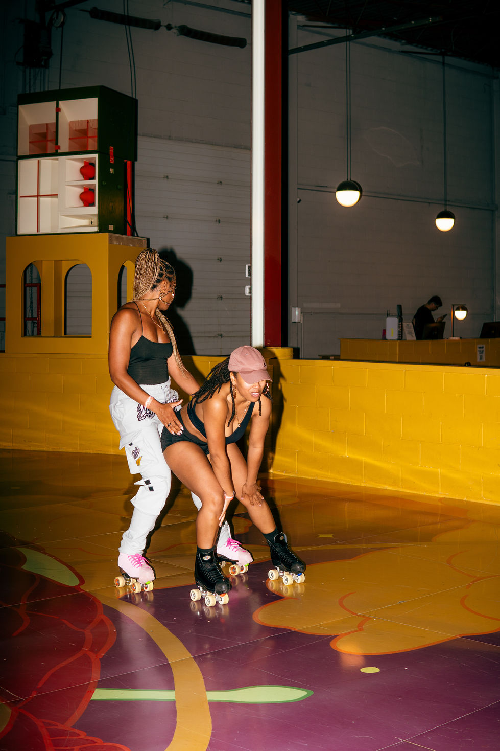 Two people roller skating indoors.