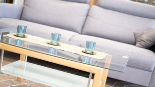 Modernes graues Sofa mit passendem Glastisch und blauer Dekoration im Sozialkaufhaus Fundus