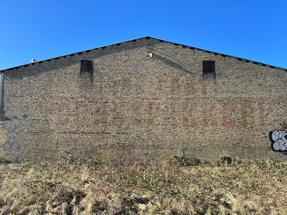 På gavlen ses stadig sporene efter "Middelfart Tobakspakkeri", som i 1950'erne byggede langs godsbanen.