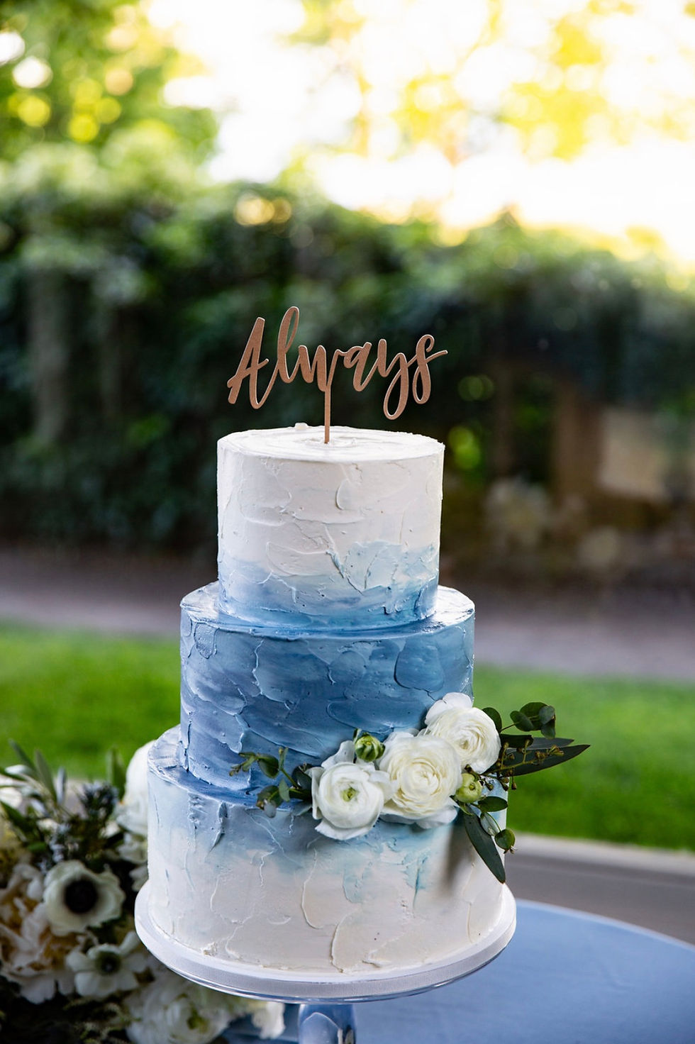 Dusty blue wedding cake with Ranunculus and Eucalyptus