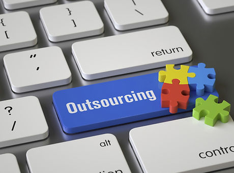 Klawiatura z napisem outsourcing na niej puzzle.